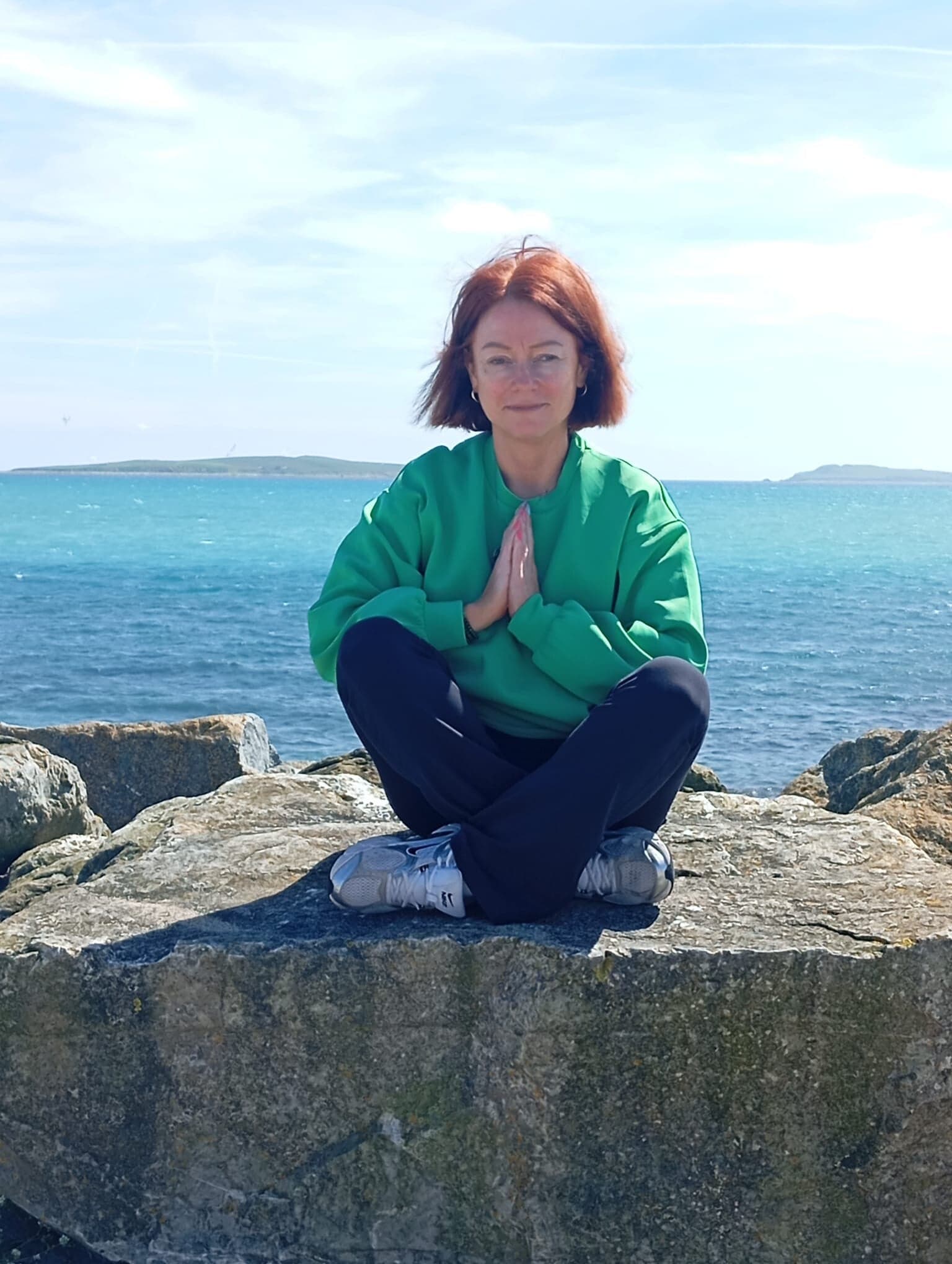 Amy Brady meditating by the sea